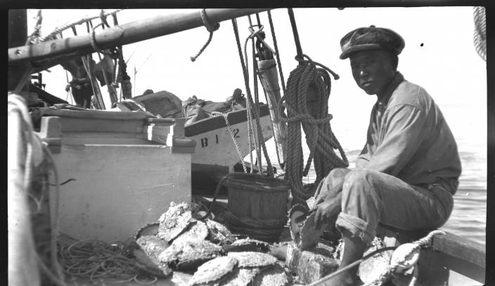 Image of a man sitting on the side of a boat.